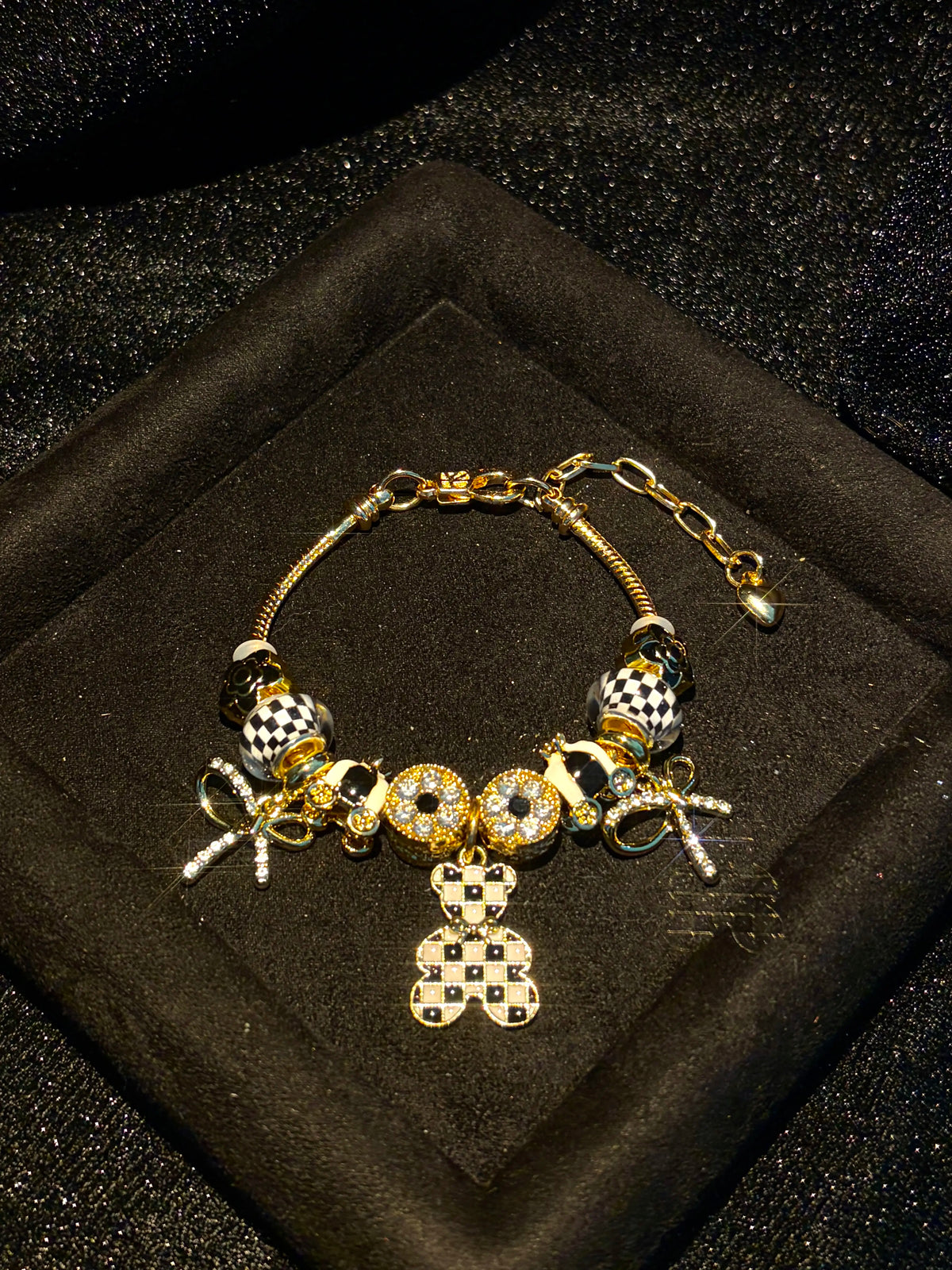 Women’s black-and-white plaid pendant bracelet with a gold-tone snake chain and beads, featuring a bow and crystal rhinestones—an elegant, luxurious jewelry gift.