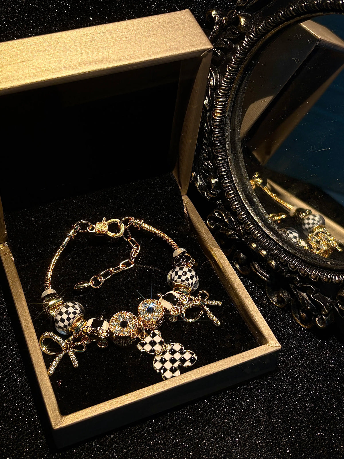 Women’s black-and-white plaid pendant bracelet with a gold-tone snake chain and beads, featuring a bow and crystal rhinestones—an elegant, luxurious jewelry gift.