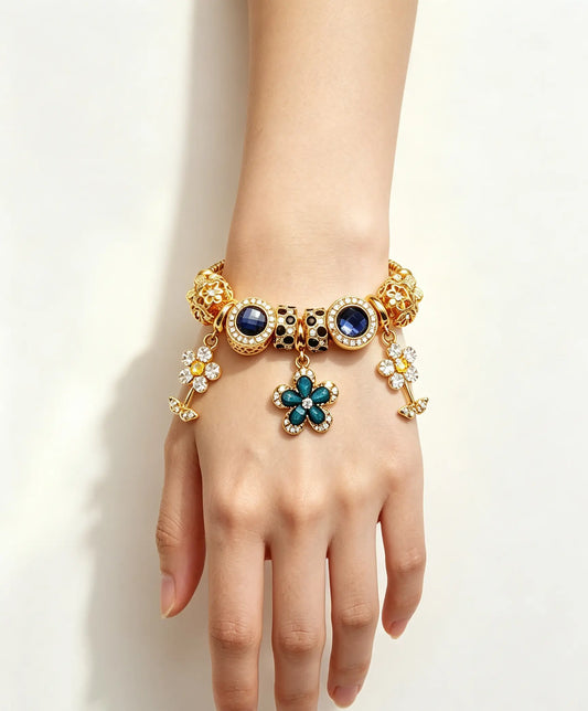 Gold-Tone Flower Charm Bracelet with Blue Crystals and Sparkling Zirconia, Fashionable Floral Pendant Design for Women's Daily Wear and Gift Giving