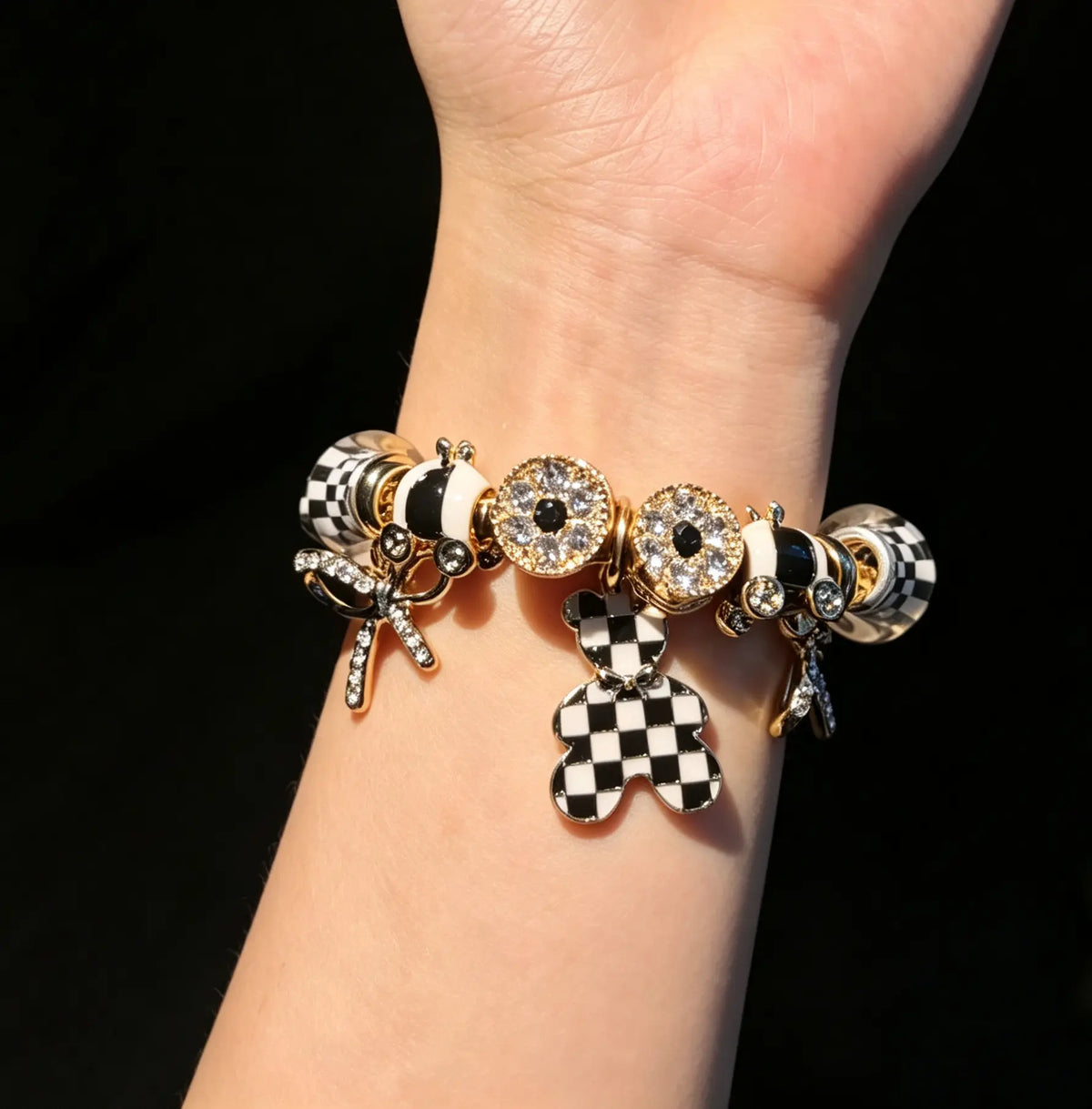 Women’s black-and-white plaid pendant bracelet with a gold-tone snake chain and beads, featuring a bow and crystal rhinestones—an elegant, luxurious jewelry gift.
